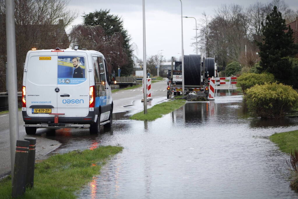 Straat onder water gelopen door kapotte waterleiding