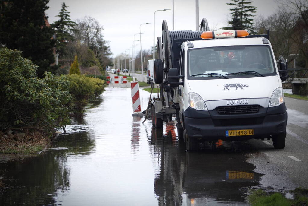 Straat onder water gelopen door kapotte waterleiding