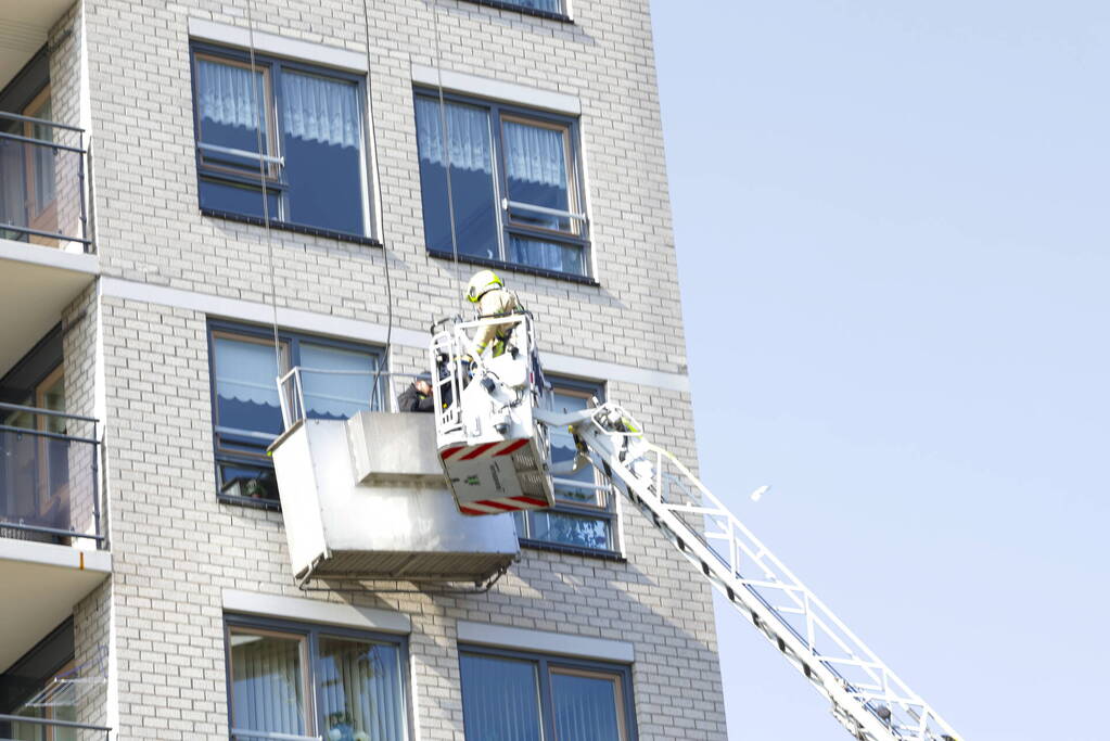 Brandweer haalt persoon uit vastzittende glazenwasserbak