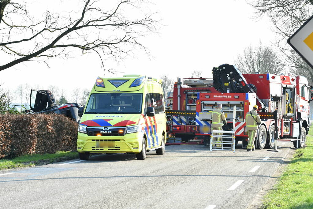 Auto raakt van de weg en belandt op zijkant in voortuin