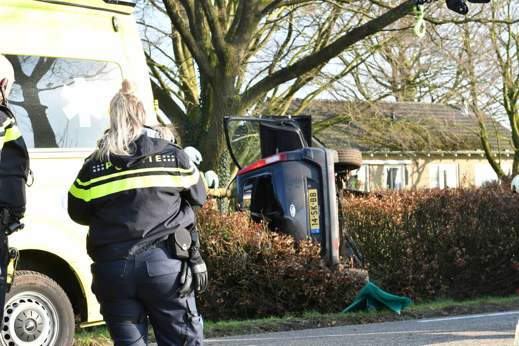 Auto raakt van de weg en belandt op zijkant in voortuin