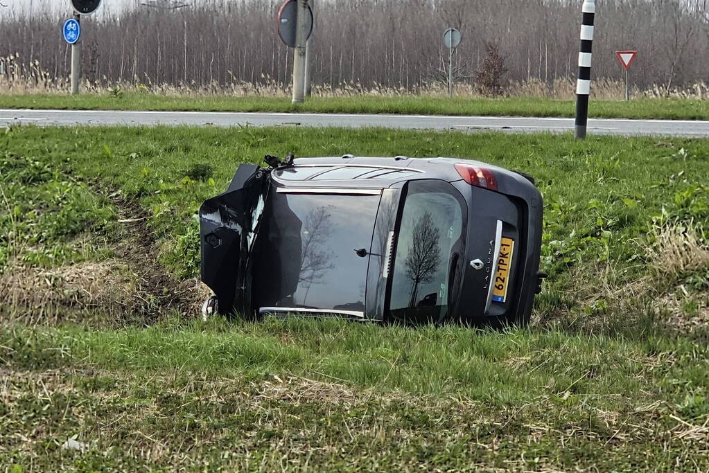 Auto ramt verkeerslicht en belandt op zijn zij in een greppel