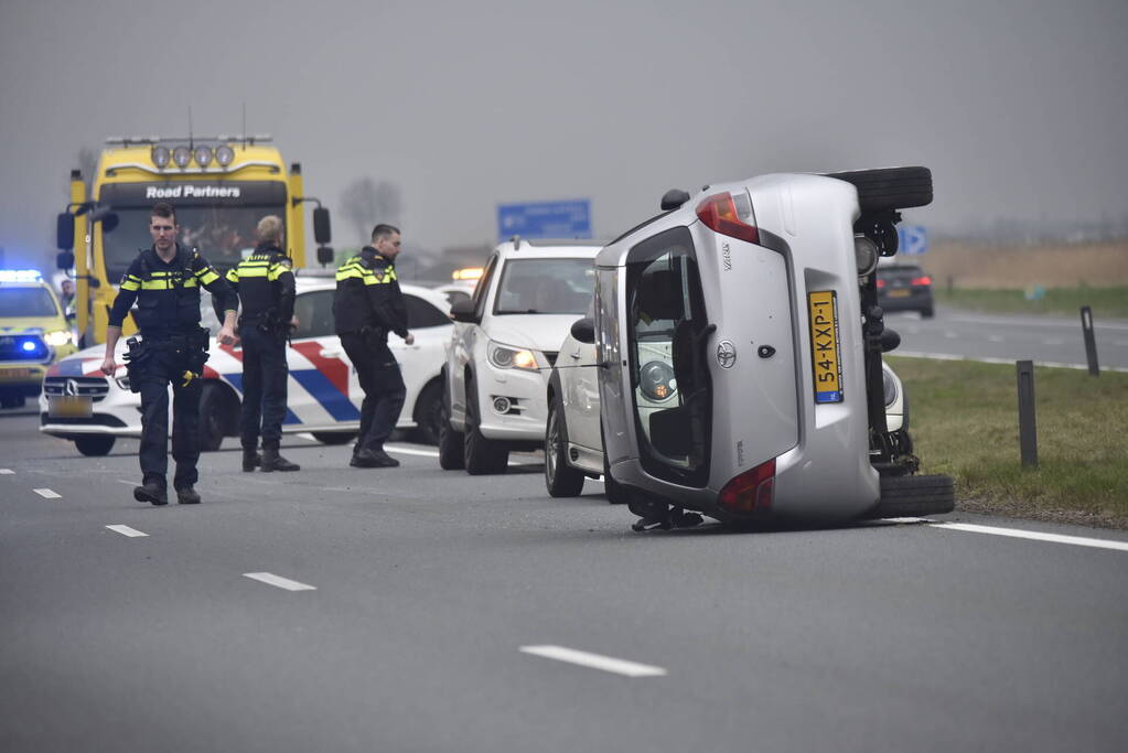 Auto op zijn kant na ongeval met vrachtwagen