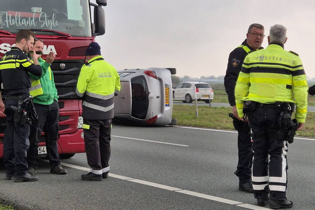 Auto op zijn kant na ongeval met vrachtwagen