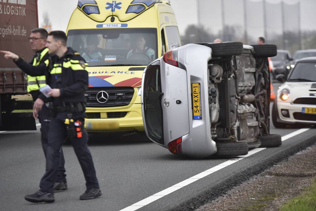 Auto op zijn kant na ongeval met vrachtwagen