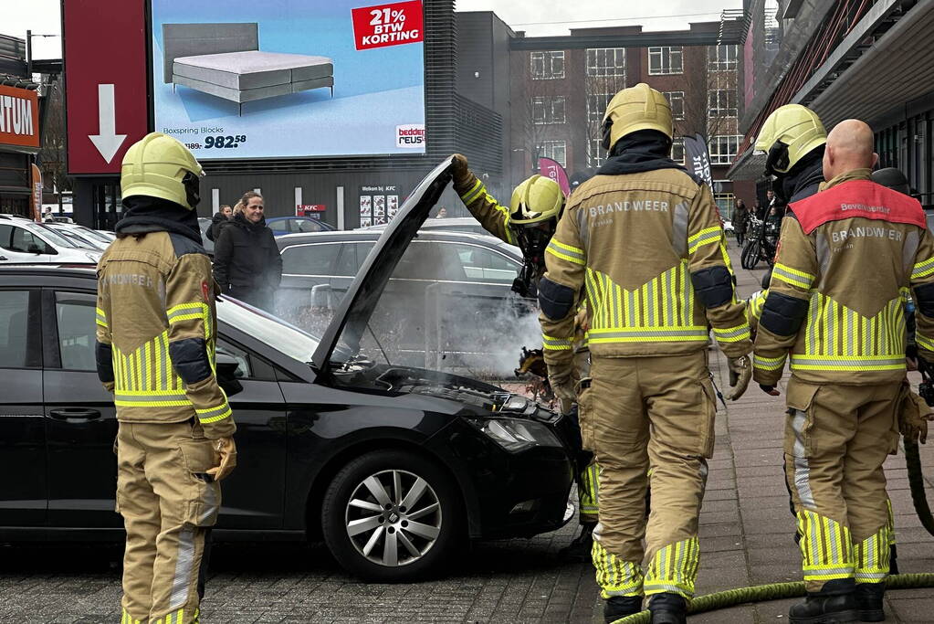 Rook onder de motorkap van de auto