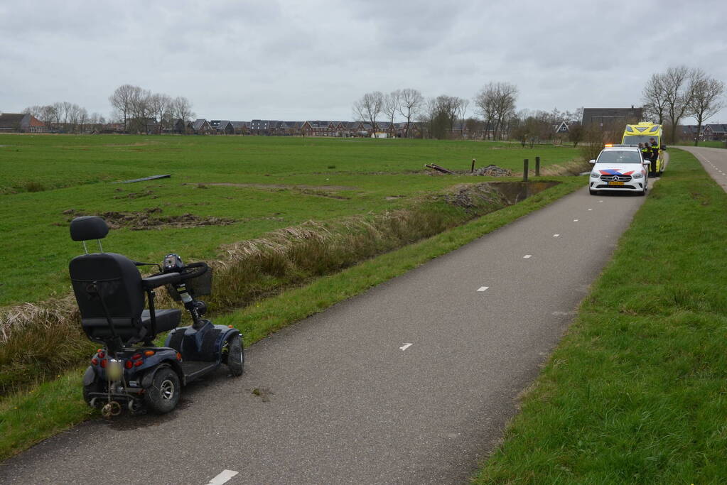 Persoon in scootmobiel raakt te water