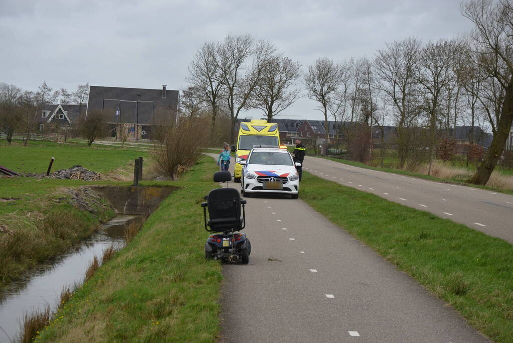 Persoon in scootmobiel raakt te water