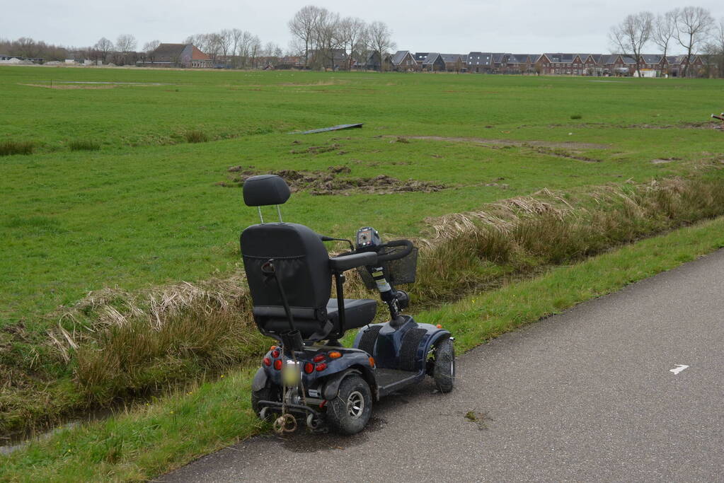 Persoon in scootmobiel raakt te water