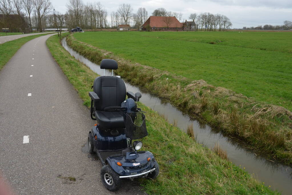 Persoon in scootmobiel raakt te water