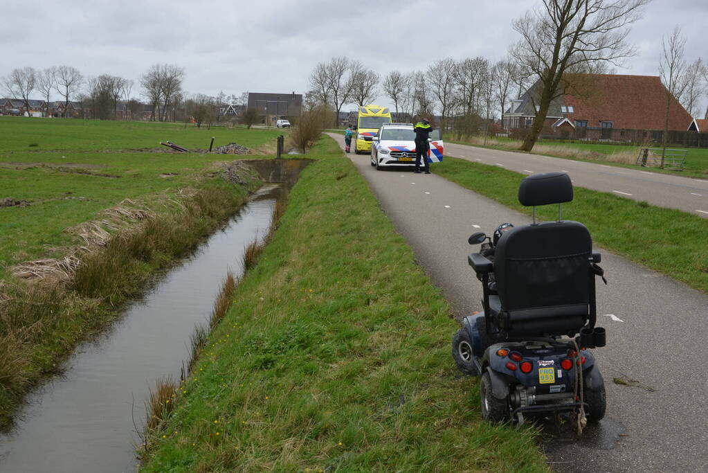 Persoon in scootmobiel raakt te water