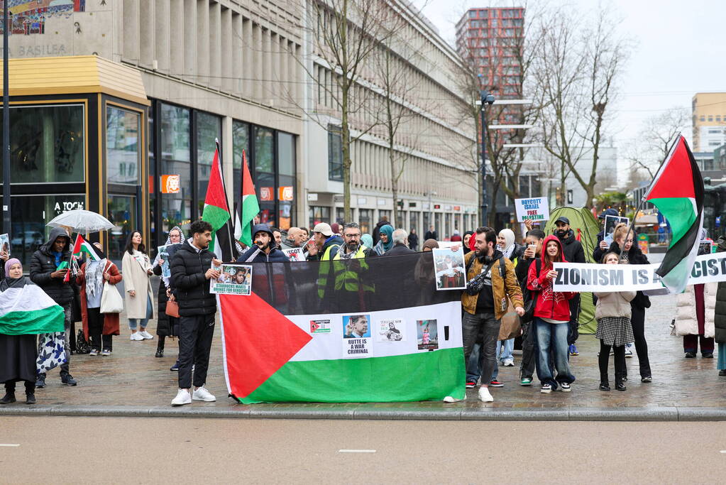 Demonstrant klimt op gebouw naast gemeentehuis