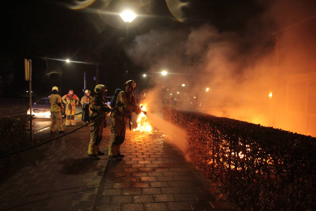 Brandweer blust kliko's die dicht bij pand staan