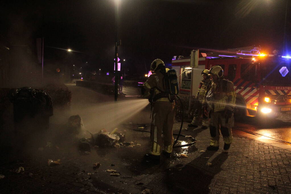 Brandweer blust kliko's die dicht bij pand staan