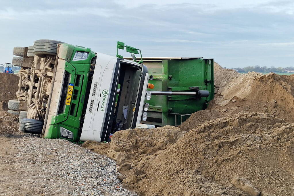 Vrachtwagen kantelt op bouwplaats