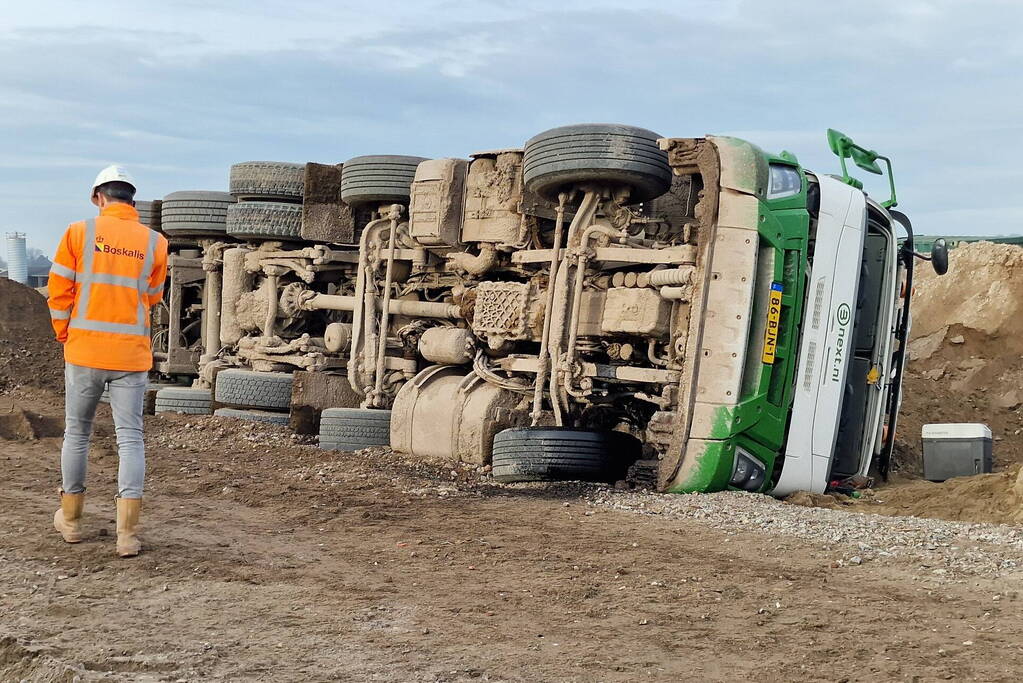 Vrachtwagen kantelt op bouwplaats