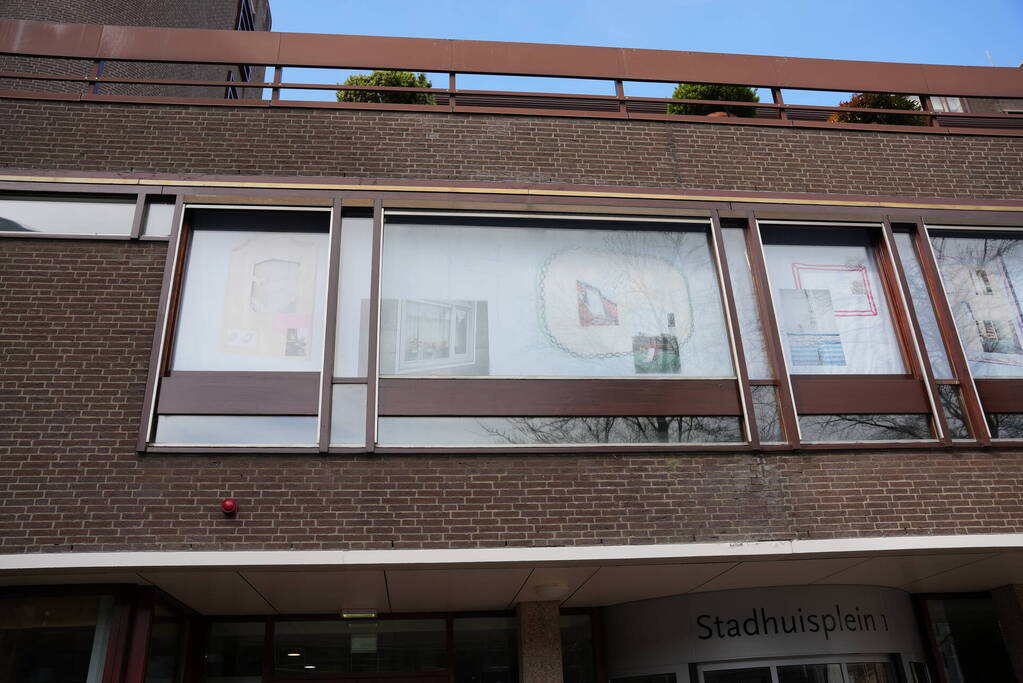 Tekeningen, foto's en bouwtekeningen als raamkunstwerk bij stadshuis