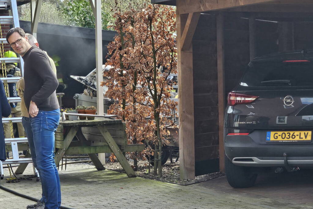 Bewoners starten blussing van brand onder carport