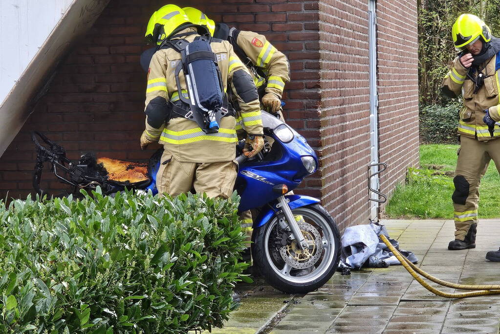 Motor in brand naast flatgebouw