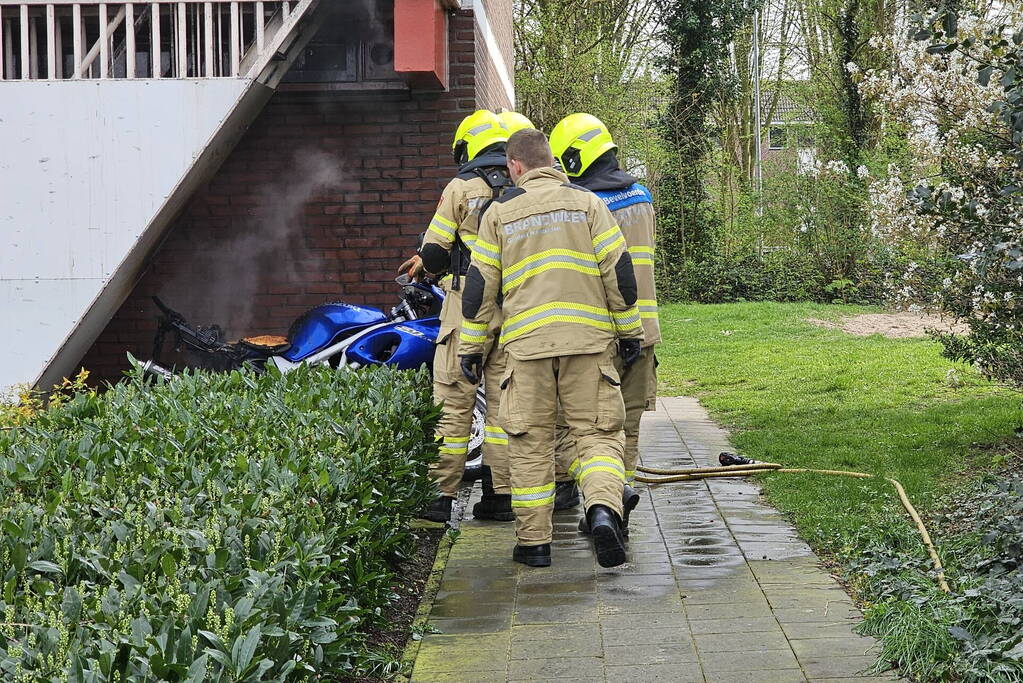 Motor in brand naast flatgebouw