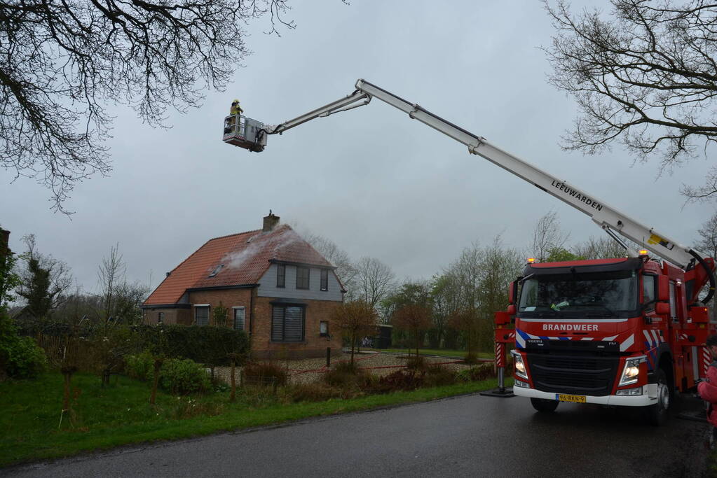 Brandweer blust brand in dak van woonboerderij