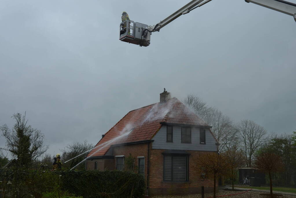 Brandweer blust brand in dak van woonboerderij