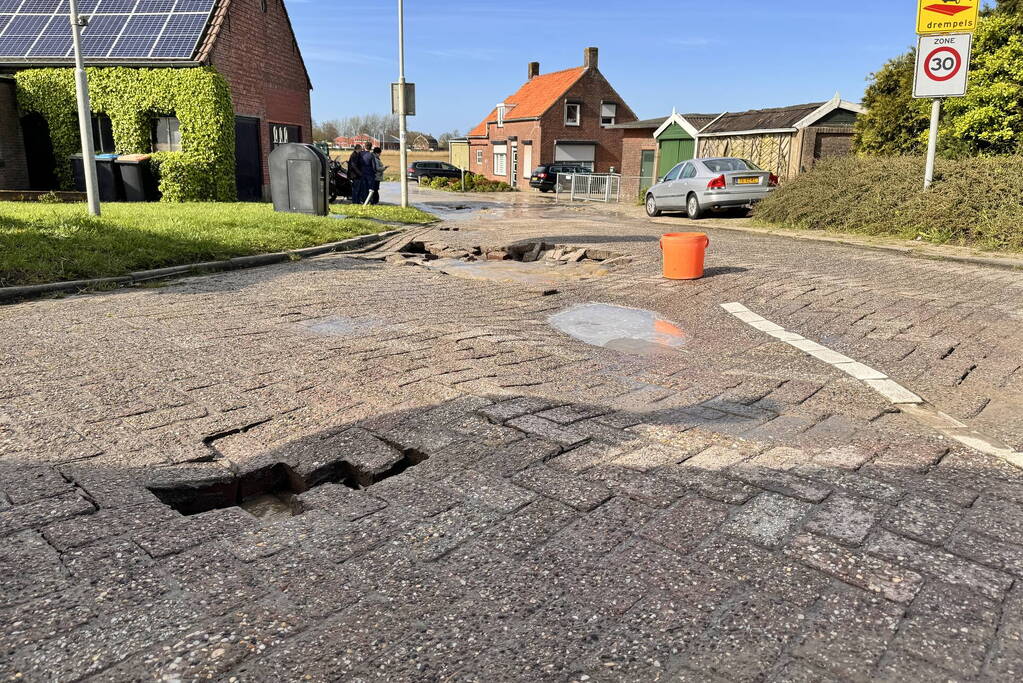 Wegdek verzakt door leidingbreuk