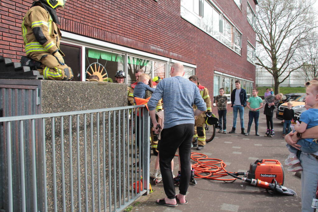 Kind bekneld tussen hek en betonnen container