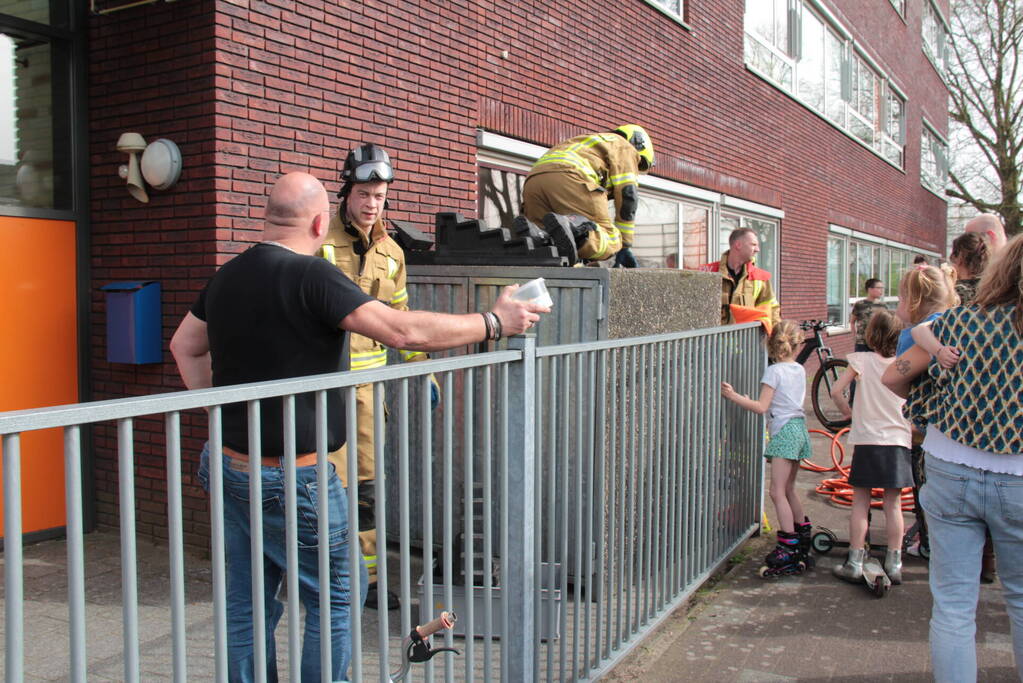 Kind bekneld tussen hek en betonnen container