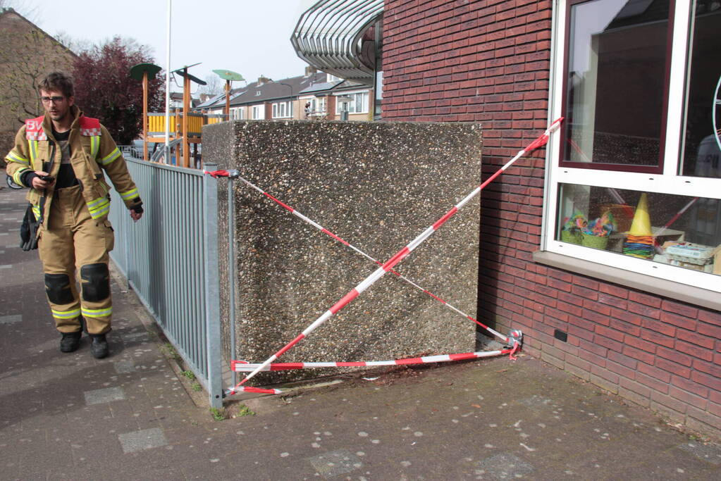 Kind bekneld tussen hek en betonnen container