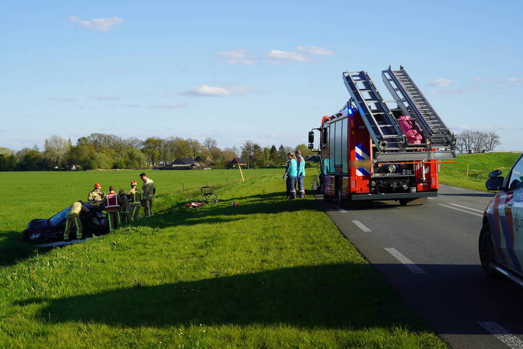 Automobilist raakt van de weg en blijft boven sloot hangen