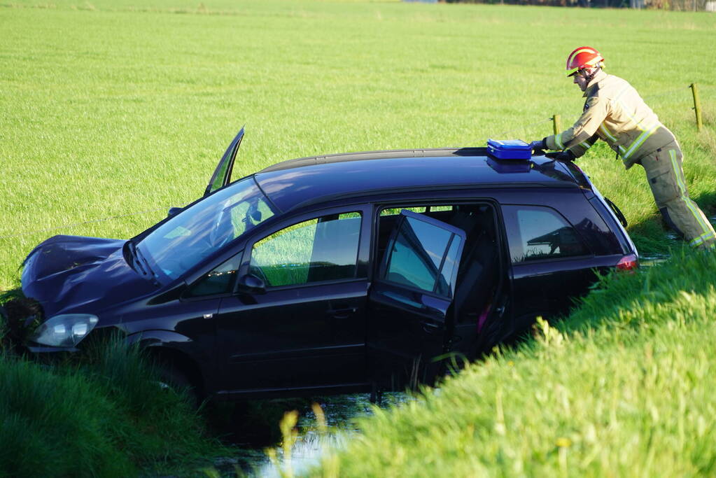 Automobilist raakt van de weg en blijft boven sloot hangen