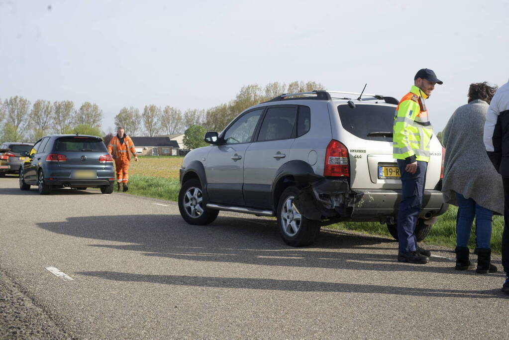 Twee auto's op elkaar wanneer bestuurders naar ander ongeval kijken