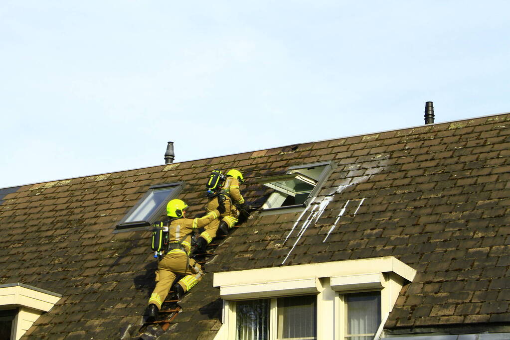 Brandweer breekt dak open om brand te bestrijden