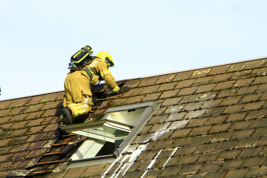 Brandweer breekt dak open om brand te bestrijden