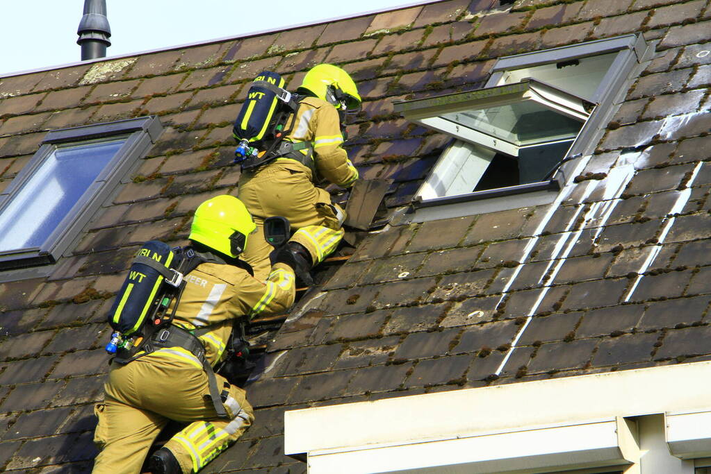 Brandweer breekt dak open om brand te bestrijden