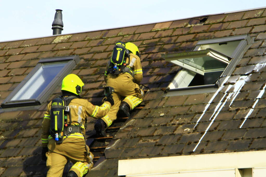 Brandweer breekt dak open om brand te bestrijden