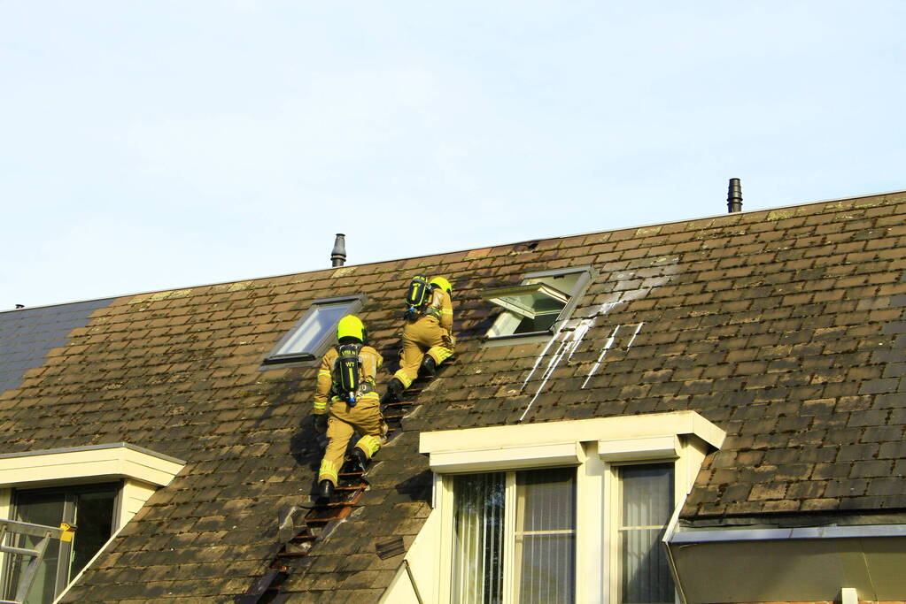 Brandweer breekt dak open om brand te bestrijden