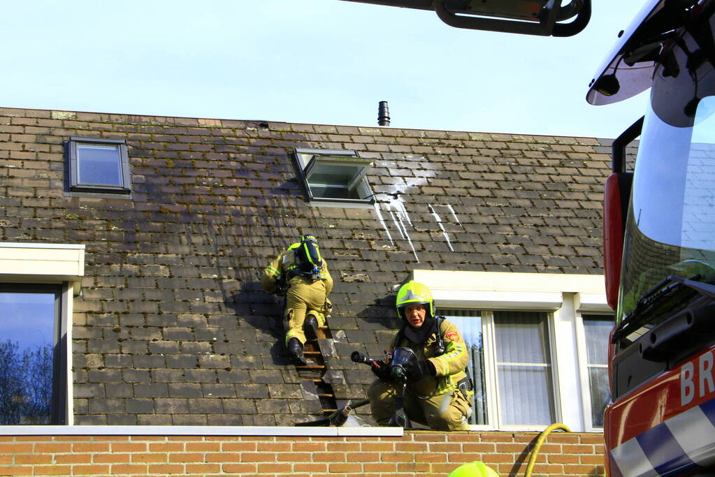 Brandweer breekt dak open om brand te bestrijden