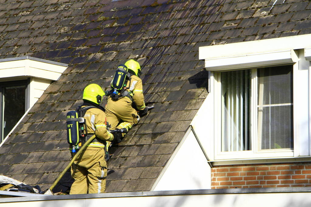 Brandweer breekt dak open om brand te bestrijden