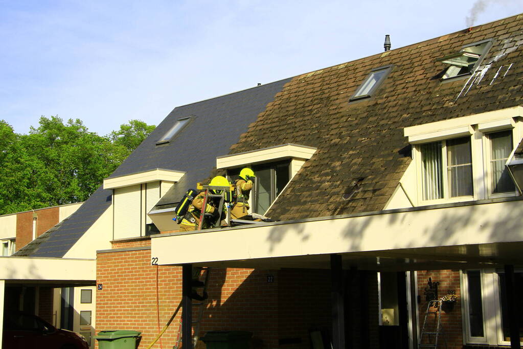 Brandweer breekt dak open om brand te bestrijden