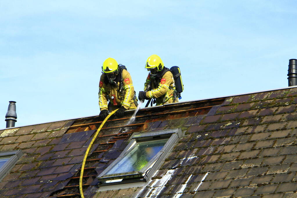 Brandweer breekt dak open om brand te bestrijden