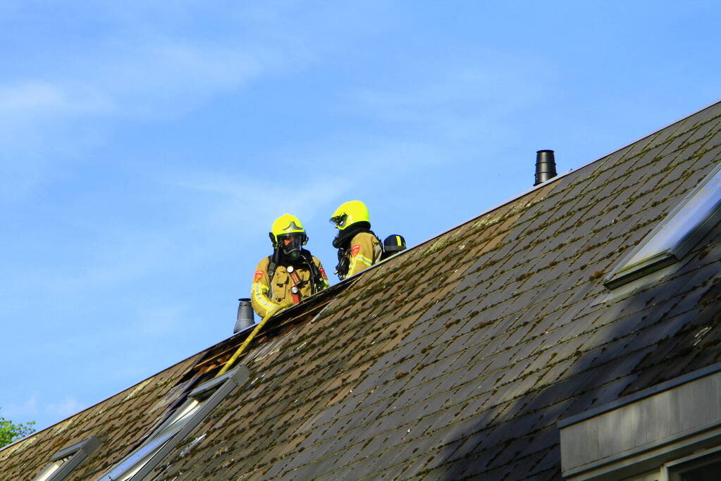 Brandweer breekt dak open om brand te bestrijden