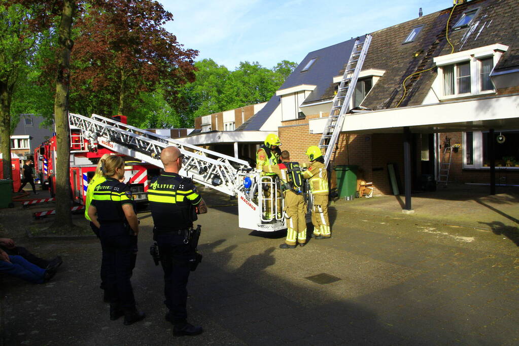 Brandweer breekt dak open om brand te bestrijden