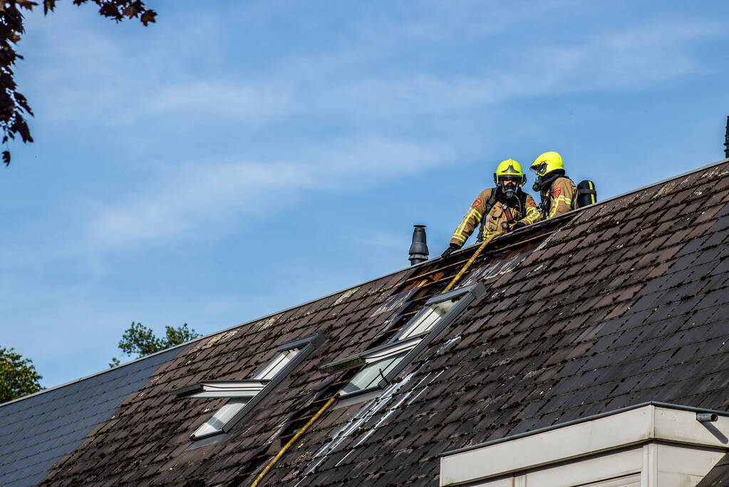 Brandweer breekt dak open om brand te bestrijden