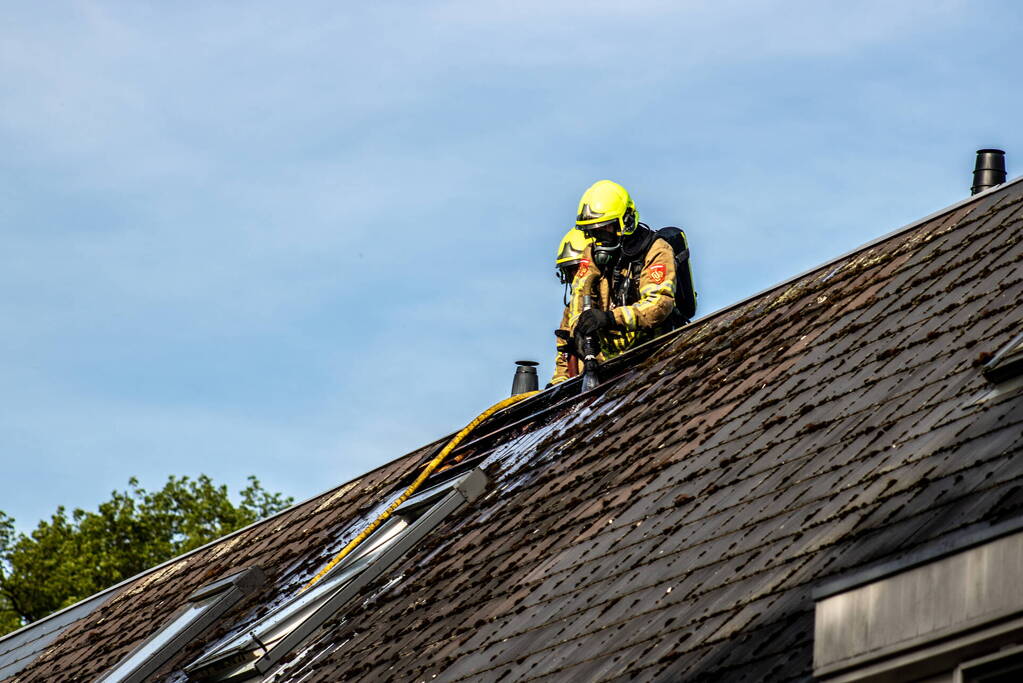 Brandweer breekt dak open om brand te bestrijden