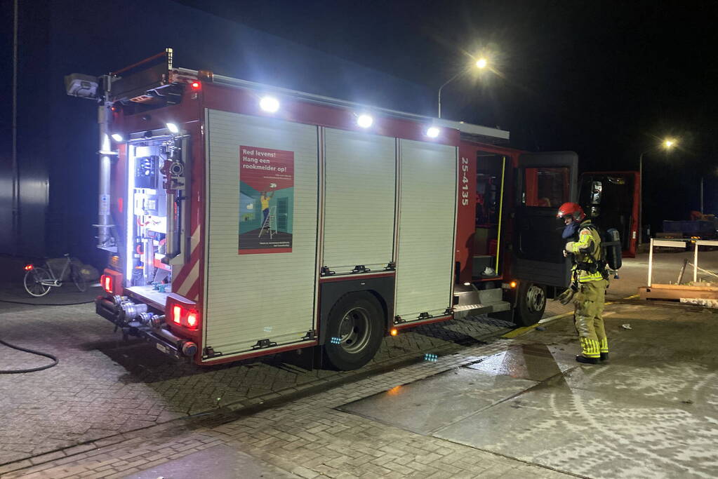 Brandweer blust brandende pallets