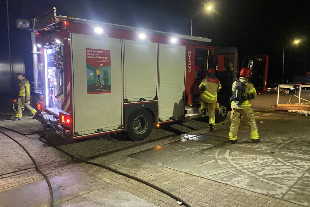 Brandweer blust brandende pallets