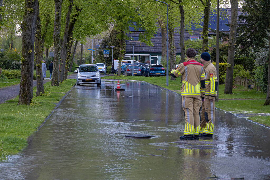 Straat onderwater door gesprongen leiding