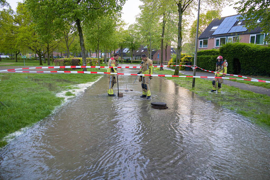 Straat onderwater door gesprongen leiding